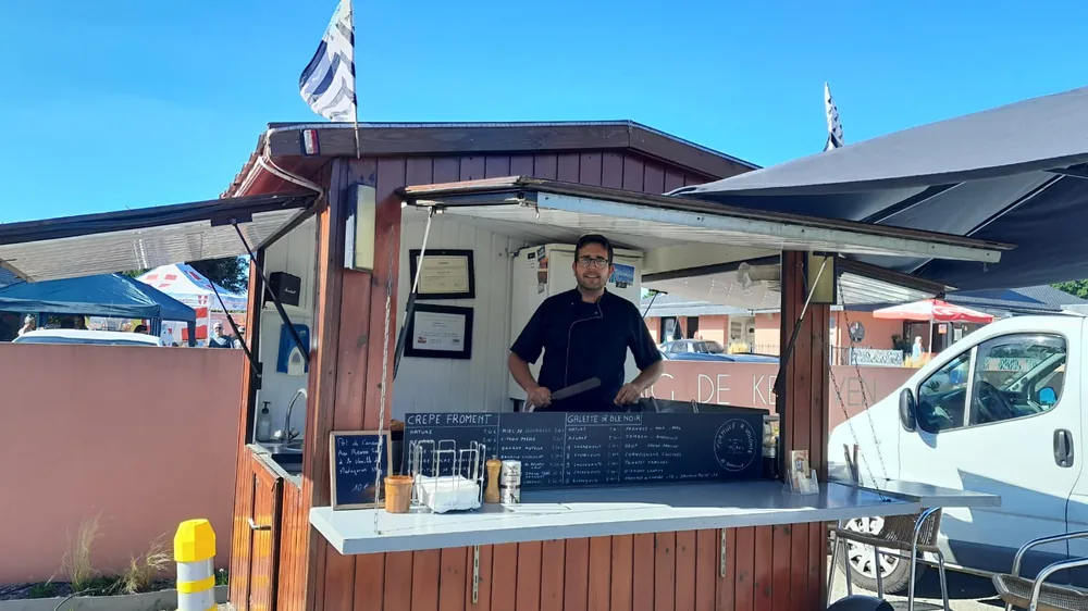 Arnaud Moalic au comptoir de la roulotte, sous le drapeau breton