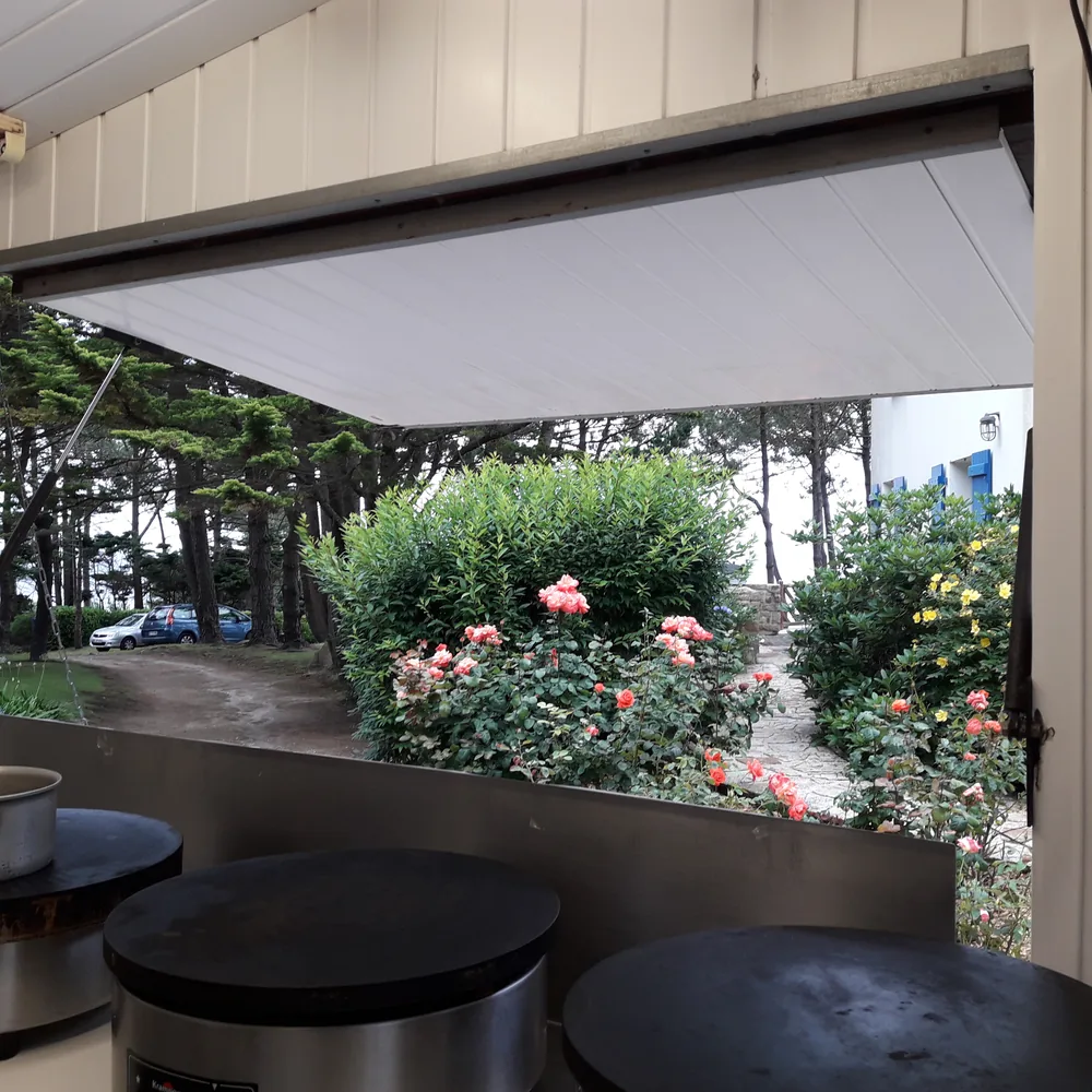 Les billigs vues de l'intérieur de la roulotte, face à un jardin fleuri