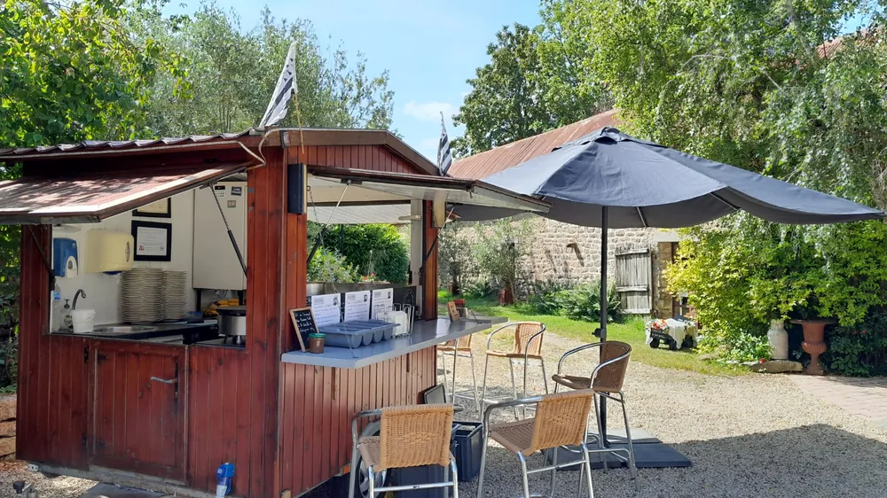 Roulotte à crêpes et parasol dans un jardin gravillonné